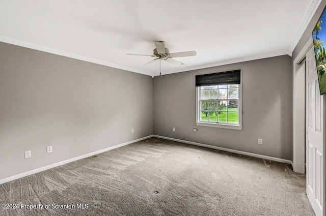 empty room featuring carpet floors, ceiling fan, and crown molding