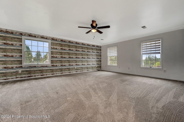 carpeted empty room with ceiling fan and ornamental molding