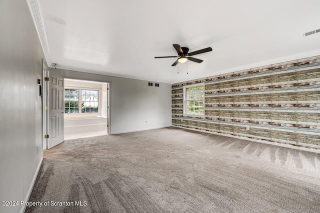 empty room featuring carpet, ceiling fan, and ornamental molding