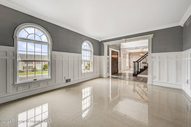 spare room with an inviting chandelier and ornamental molding