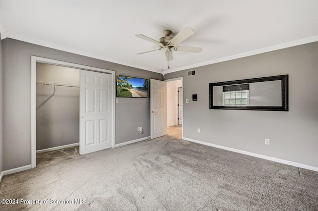 unfurnished bedroom with carpet flooring, ceiling fan, a closet, and ornamental molding