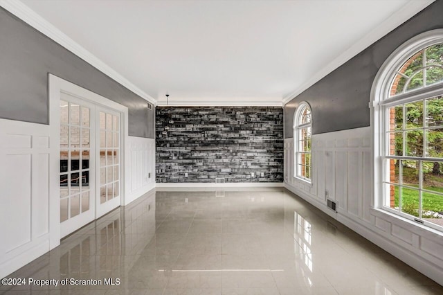 tiled empty room with a healthy amount of sunlight and ornamental molding