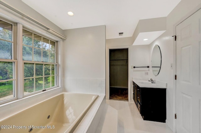 bathroom featuring tile patterned floors, tiled tub, and vanity