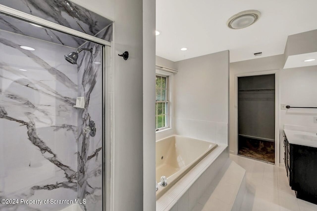 bathroom featuring tile patterned flooring, shower with separate bathtub, and vanity