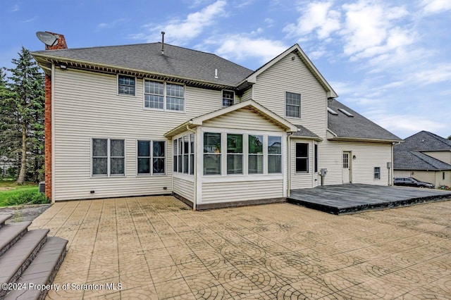 back of property with a sunroom and a wooden deck