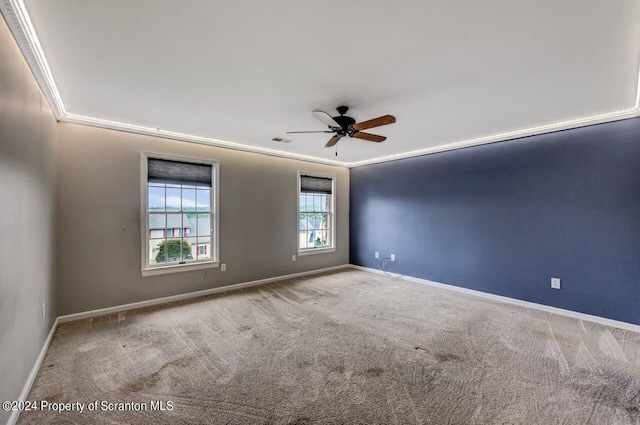 carpeted empty room with ceiling fan and ornamental molding