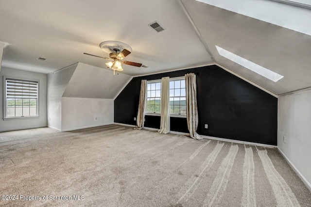 bonus room featuring lofted ceiling with skylight, plenty of natural light, and ceiling fan