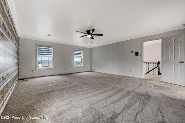 carpeted empty room featuring ceiling fan and ornamental molding