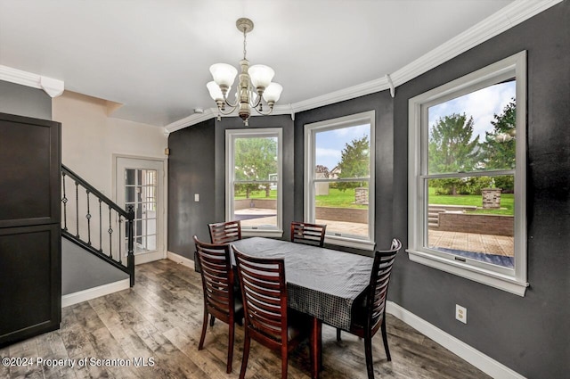 dining room featuring wood-type flooring, ornamental molding, and an inviting chandelier