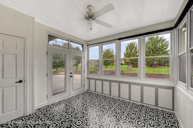 unfurnished sunroom with ceiling fan and french doors