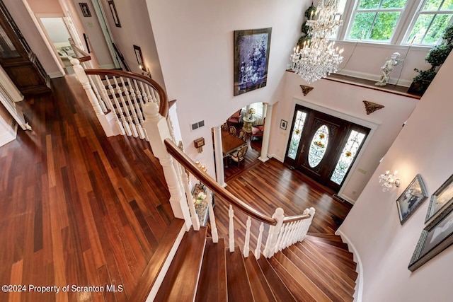 entryway with dark wood-type flooring, a high ceiling, and a chandelier