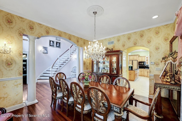 dining space featuring a chandelier, hardwood / wood-style floors, decorative columns, and crown molding