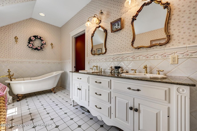 bathroom with tile patterned floors, a bathtub, vanity, and tile walls