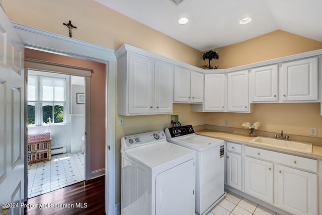 clothes washing area featuring cabinets, sink, separate washer and dryer, a baseboard radiator, and light tile patterned flooring