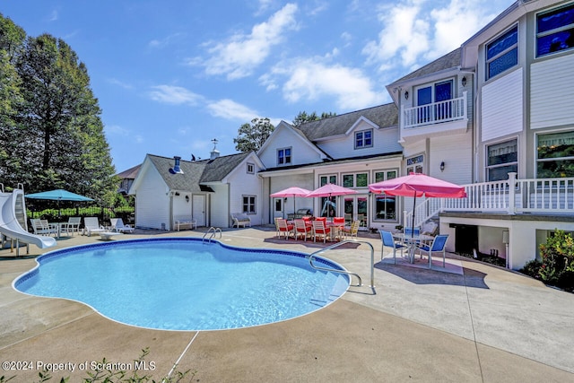 view of swimming pool with a patio area and a water slide