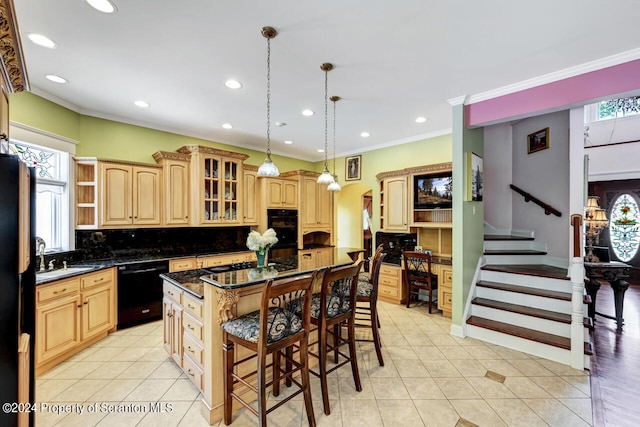 kitchen featuring dark stone countertops, pendant lighting, a breakfast bar, a kitchen island, and black appliances