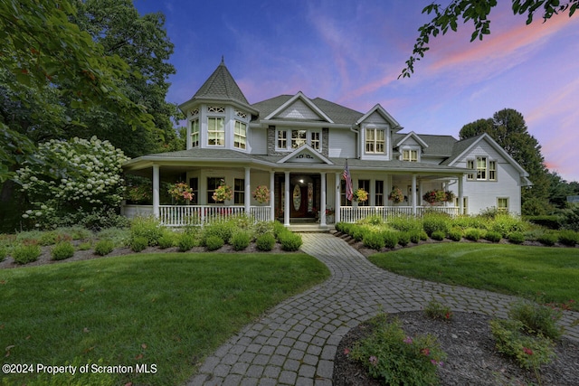 victorian home with a lawn and covered porch