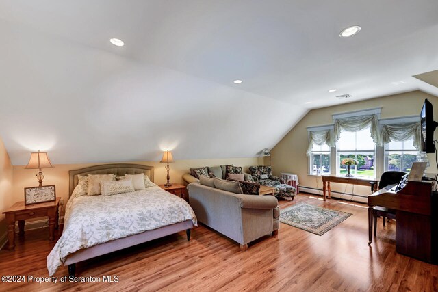 bedroom with hardwood / wood-style floors, lofted ceiling, and baseboard heating