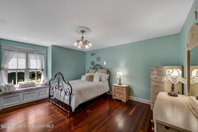 bedroom featuring dark hardwood / wood-style floors and an inviting chandelier