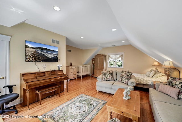 living room with light hardwood / wood-style floors and lofted ceiling