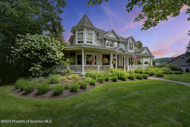 victorian home with a lawn and a porch