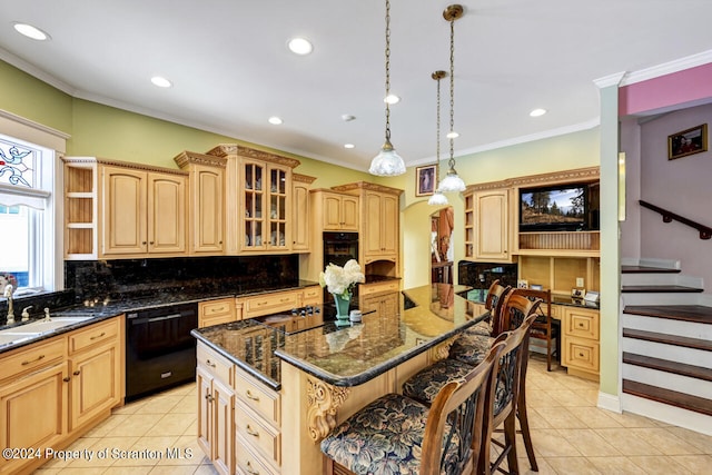 kitchen featuring sink, dark stone counters, decorative light fixtures, a kitchen island, and black appliances