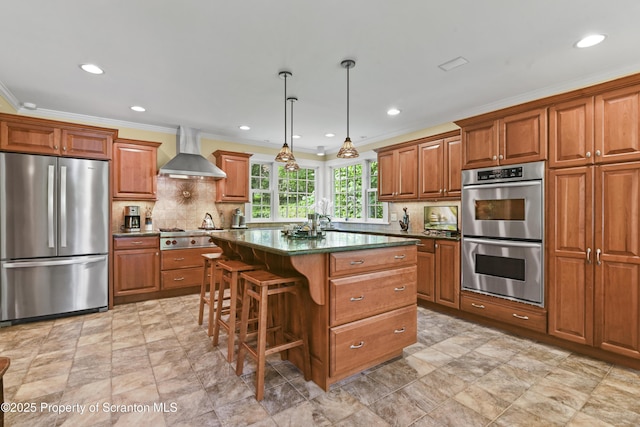 218 Weatherby St, Dalton, PA 18414 - kitchen featuring brown cabinetry, wall chimney range hood, appliances with stainless steel finishes, and a kitchen island