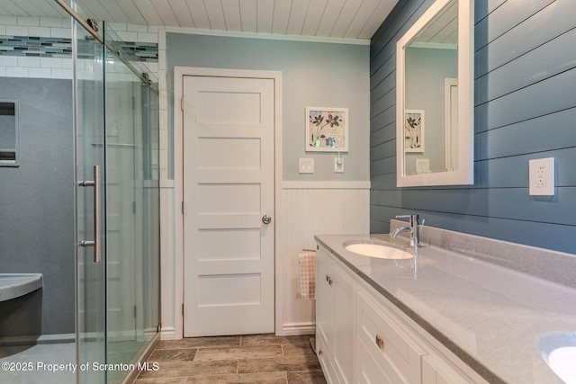 144 Crosstown Hwy, Union Dale, PA 18470 - full bathroom featuring double vanity, a stall shower, crown molding, wood walls, and wood finish floors