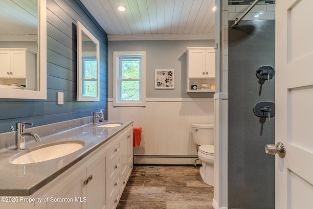 144 Crosstown Hwy, Union Dale, PA 18470 - full bath with a baseboard radiator, wood finished floors, a wainscoted wall, wooden walls, and double vanity