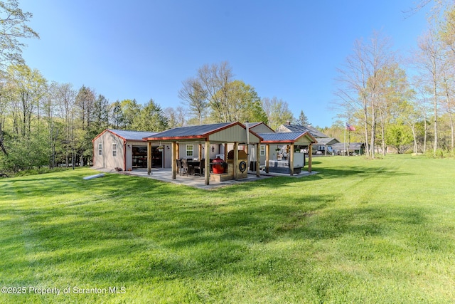 144 Crosstown Hwy, Union Dale, PA 18470 - rear view of house featuring a patio, a lawn, and a metal roof