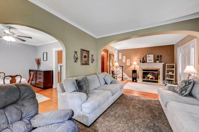 1120 Woodlawn St Unit L10, Scranton, PA 18509 - living area with light wood-type flooring, ceiling fan, crown molding, arched walkways, and a glass covered fireplace