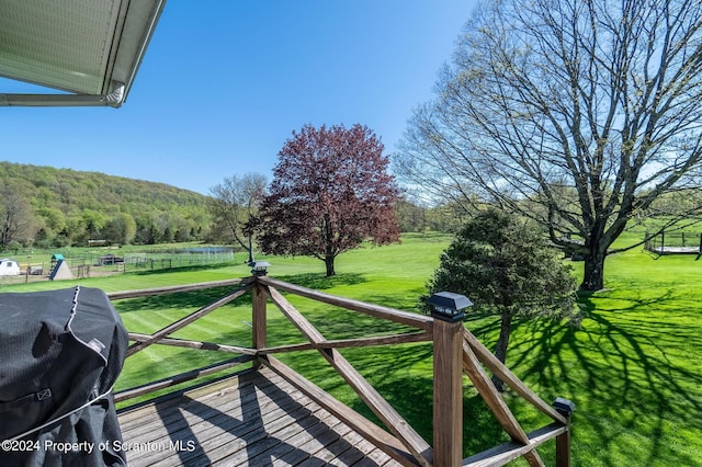 wooden deck with grilling area and a yard