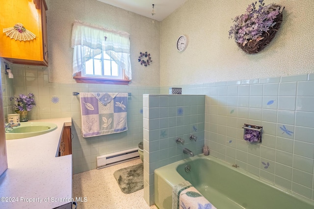 bathroom featuring vanity, toilet, a tub to relax in, baseboard heating, and tile walls