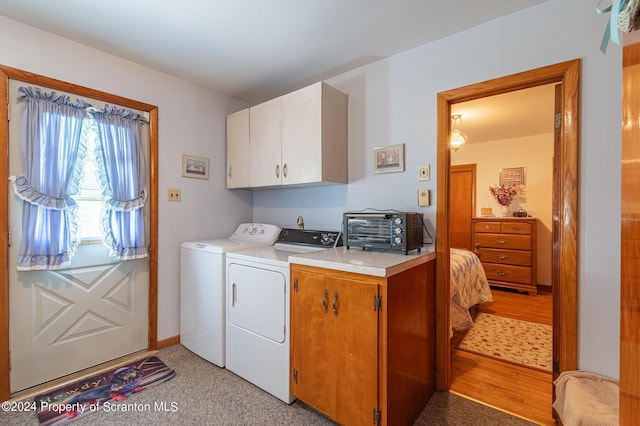 laundry room featuring cabinets and washer and clothes dryer