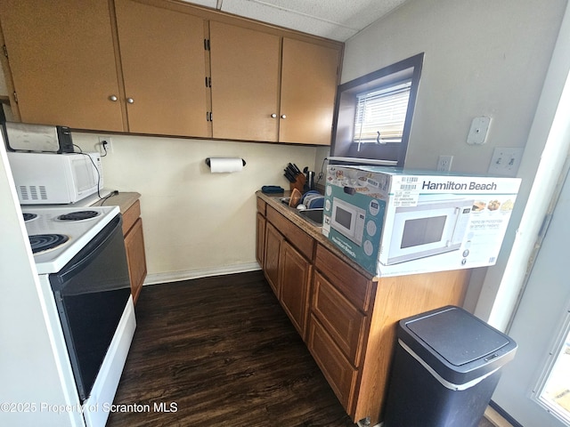 kitchen with white appliances, dark wood-style floors, and baseboards