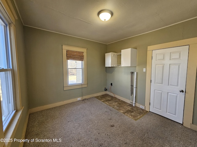 laundry room with carpet, cabinet space, and baseboards