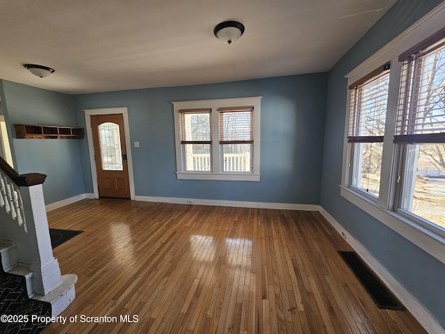 foyer entrance with visible vents, stairs, baseboards, and hardwood / wood-style floors