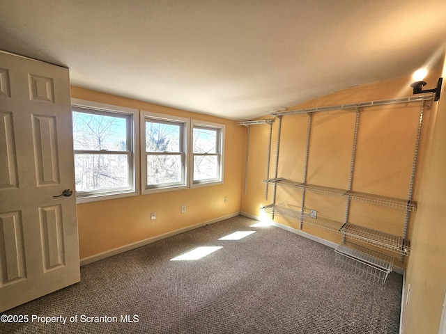 carpeted empty room with baseboards and lofted ceiling