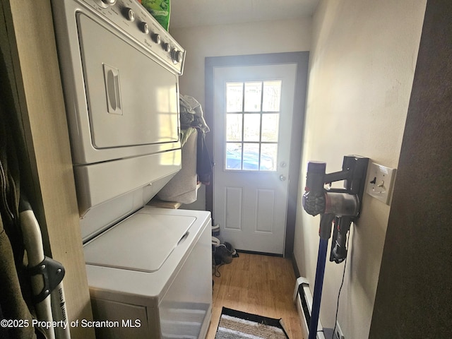 clothes washing area with laundry area, stacked washer / dryer, and wood finished floors