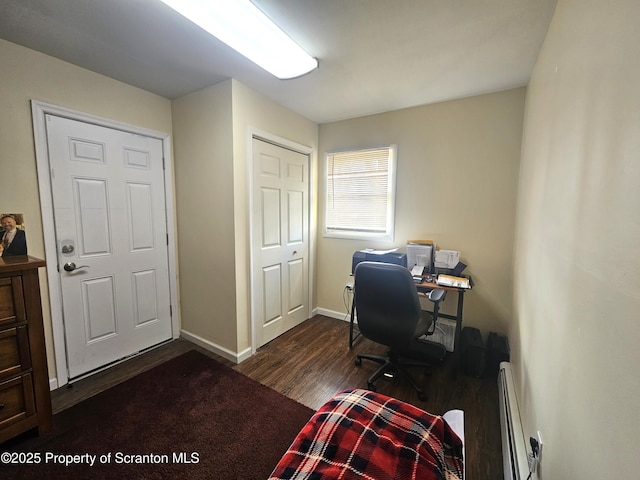 office with baseboards, baseboard heating, and dark wood-style flooring