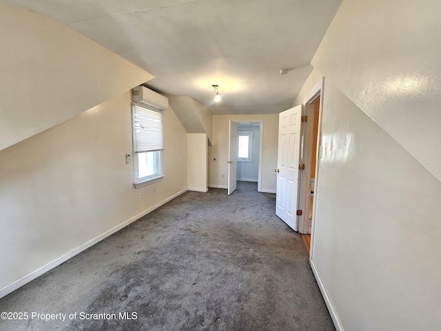 bonus room with baseboards, carpet, and a wall unit AC