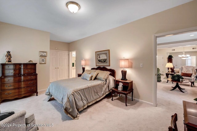 carpeted bedroom with a closet and a chandelier