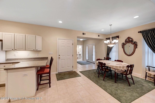 dining room featuring a notable chandelier and light tile patterned flooring