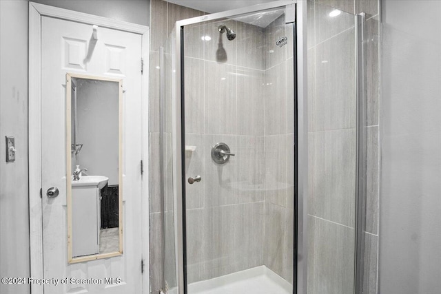 bathroom featuring an enclosed shower and sink