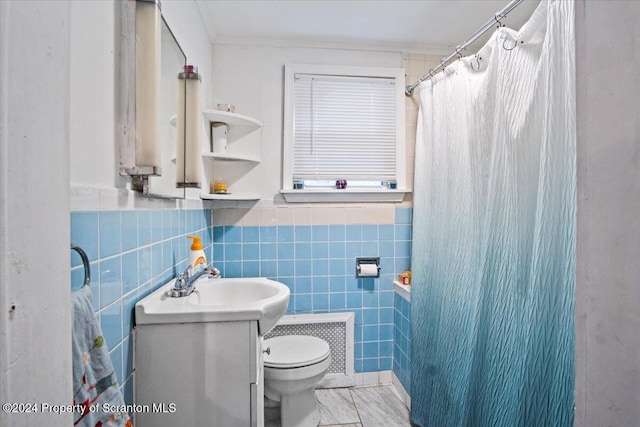 bathroom with a shower with shower curtain, vanity, crown molding, tile walls, and toilet