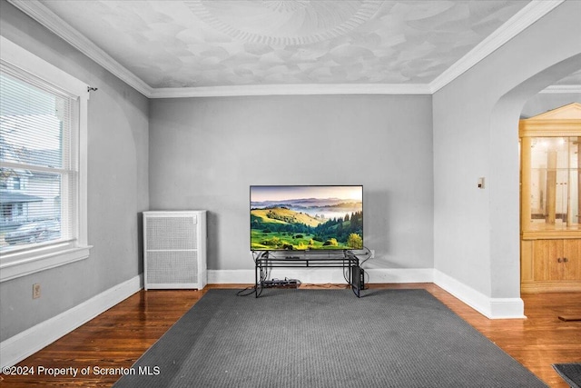 living area with a healthy amount of sunlight, dark hardwood / wood-style flooring, and crown molding