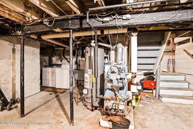 basement featuring washing machine and clothes dryer, sink, and water heater