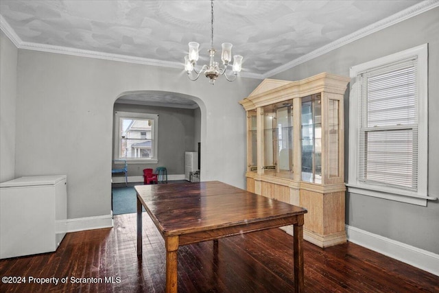 dining space with dark hardwood / wood-style flooring, an inviting chandelier, and ornamental molding