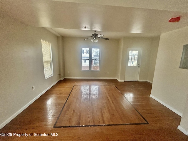 empty room featuring ceiling fan, baseboards, and wood finished floors