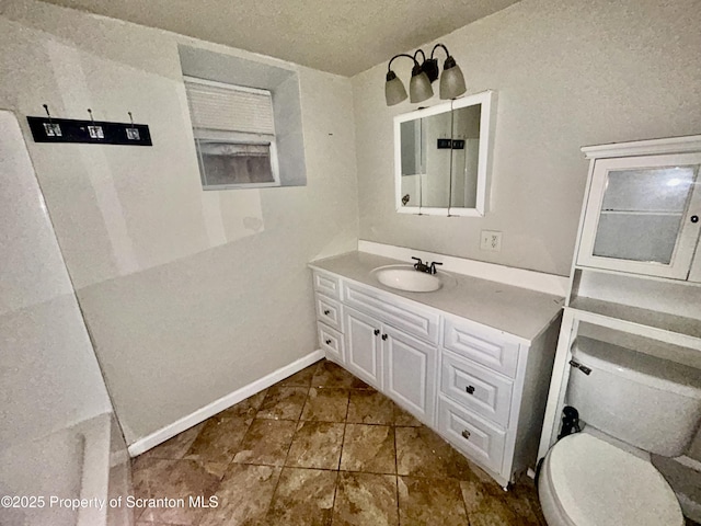 bathroom featuring baseboards, toilet, vanity, tile patterned floors, and a textured ceiling